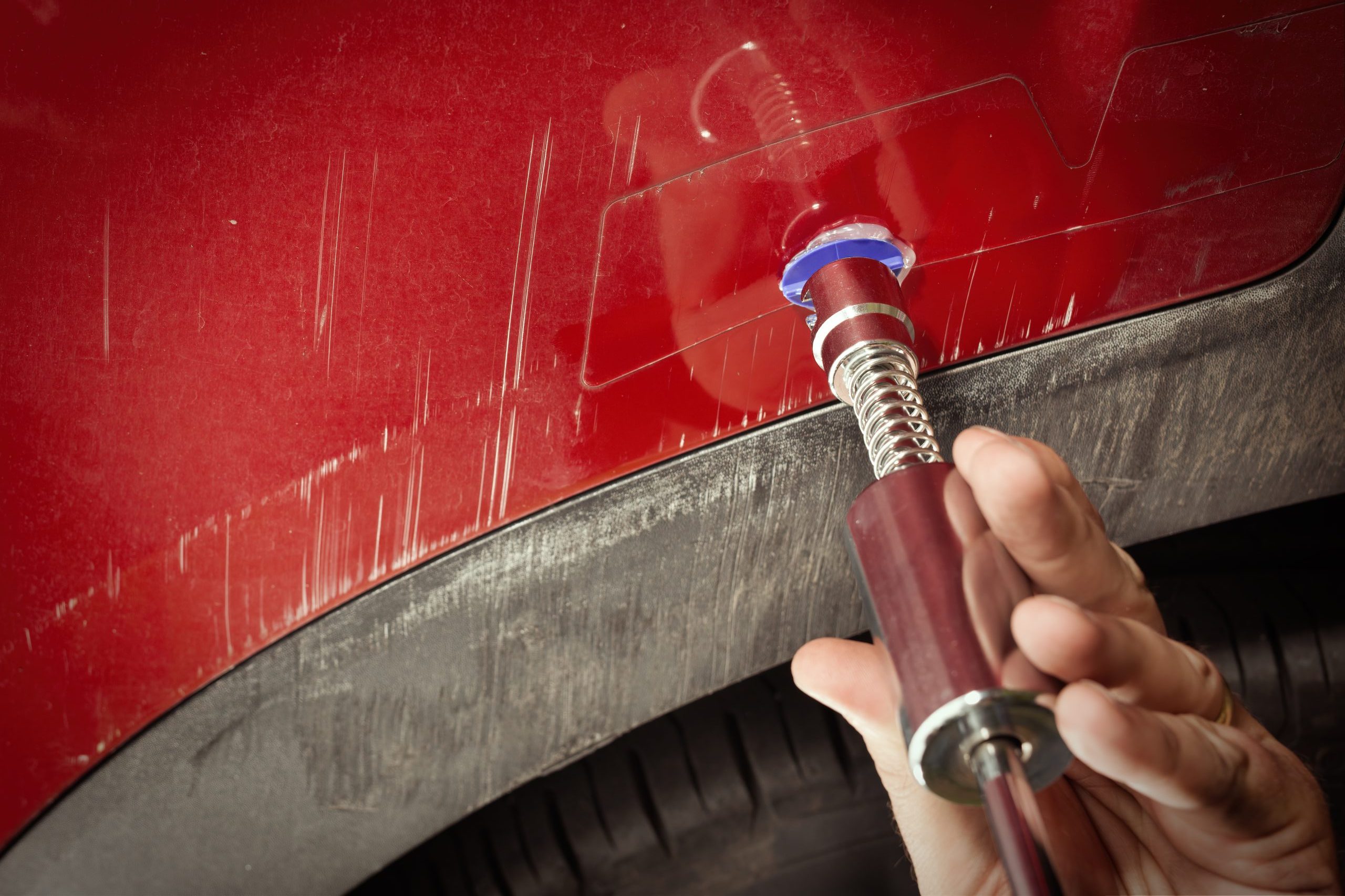 A panel beater buffing out scratches for car repairs